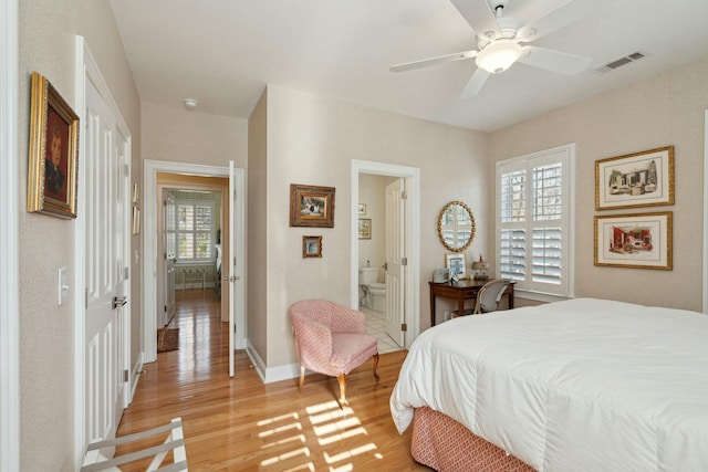 bedroom with baseboards, visible vents, ceiling fan, ensuite bathroom, and light wood-type flooring