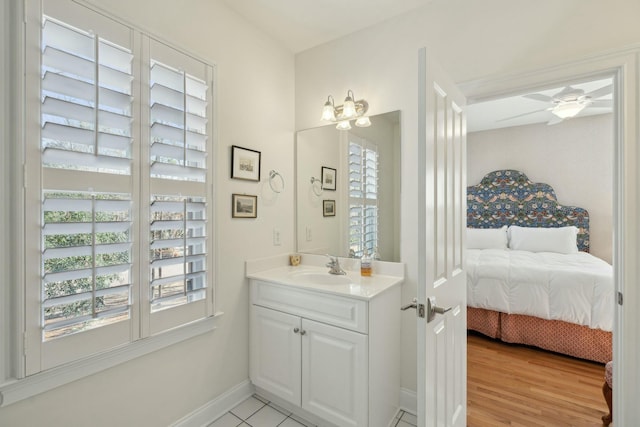 ensuite bathroom featuring baseboards, ceiling fan, wood finished floors, ensuite bathroom, and vanity