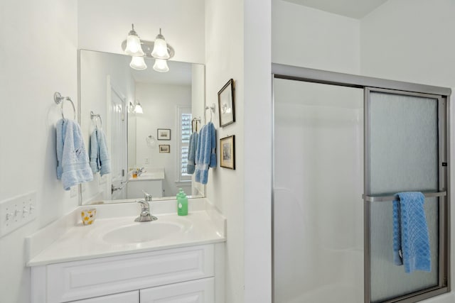 bathroom with a shower stall and vanity