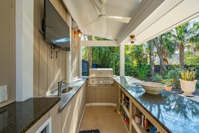 view of patio / terrace featuring a grill, a sink, ceiling fan, exterior kitchen, and a fenced backyard