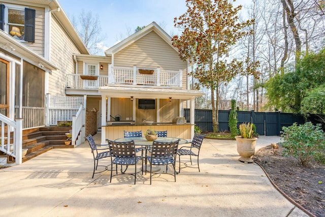 view of patio / terrace with outdoor dry bar, fence, and a balcony