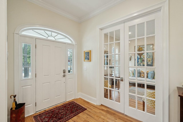 entrance foyer featuring light wood-style floors, french doors, crown molding, and baseboards