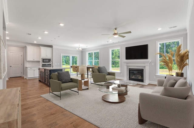 263 Huguenot Trl, Huger, SC 29450 - living room featuring ornamental molding, a fireplace with flush hearth, a ceiling fan, recessed lighting, and light wood-style floors
