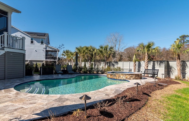 view of pool featuring a patio area, a fenced backyard, and a pool with connected hot tub