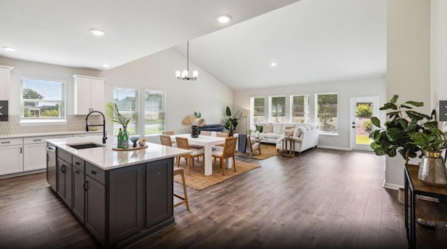 kitchen with sink, dishwasher, backsplash, white cabinetry, and dark hardwood / wood-style floors