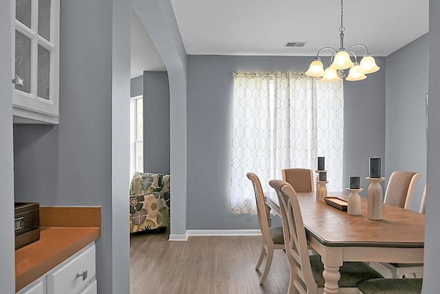 dining room featuring a chandelier, light wood-style floors, and baseboards