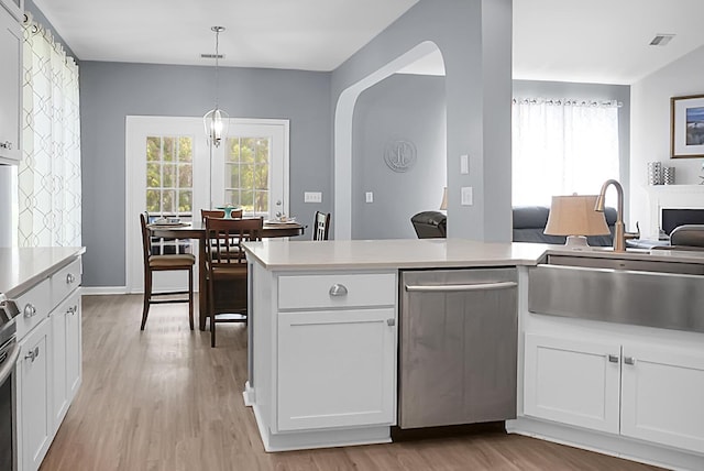 kitchen with a sink, dishwasher, light wood finished floors, and healthy amount of natural light