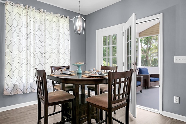 dining space featuring wood finished floors, french doors, and baseboards