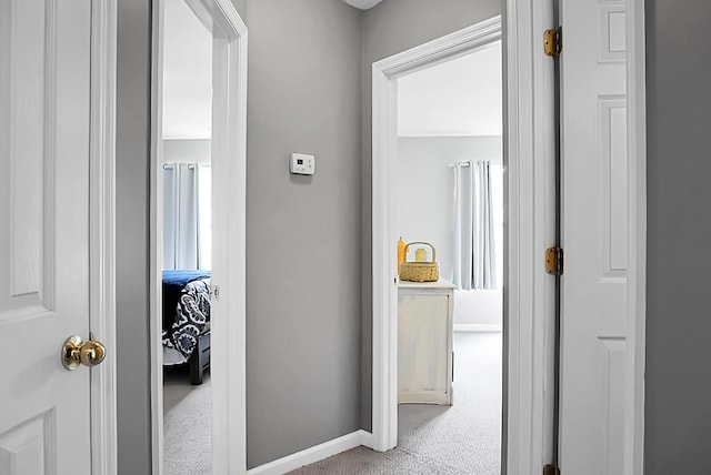 corridor with carpet floors and baseboards
