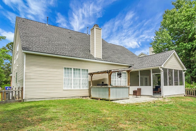 back of house with a sunroom, a chimney, a patio, and roof with shingles