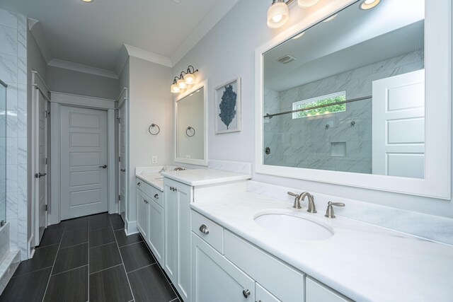 full bathroom featuring tiled shower, ornamental molding, two vanities, and tile patterned flooring