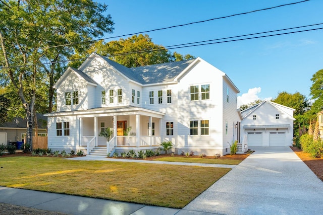modern farmhouse style home featuring covered porch, a front yard, driveway, and an outdoor structure