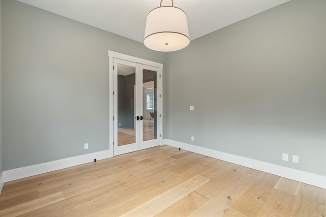 empty room featuring french doors and hardwood / wood-style flooring