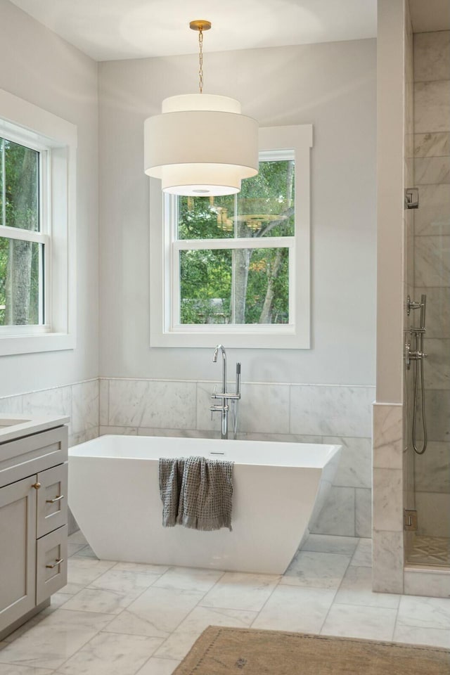 bathroom with vanity, independent shower and bath, and tile walls