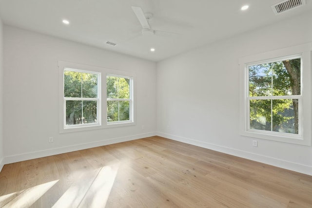 spare room with light wood-type flooring and ceiling fan