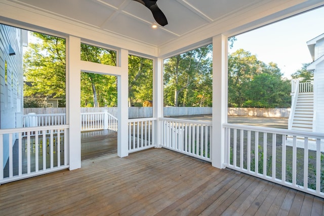 unfurnished sunroom featuring ceiling fan and a wealth of natural light