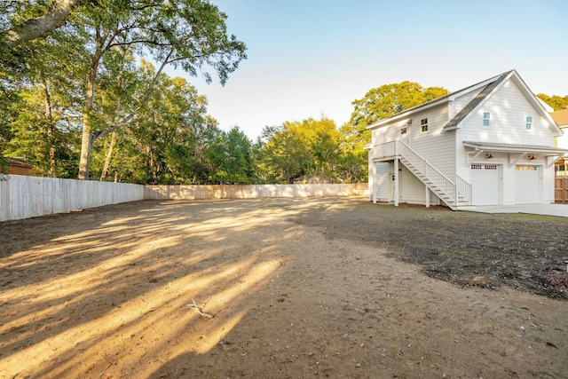 exterior space with fence, stairway, and a garage