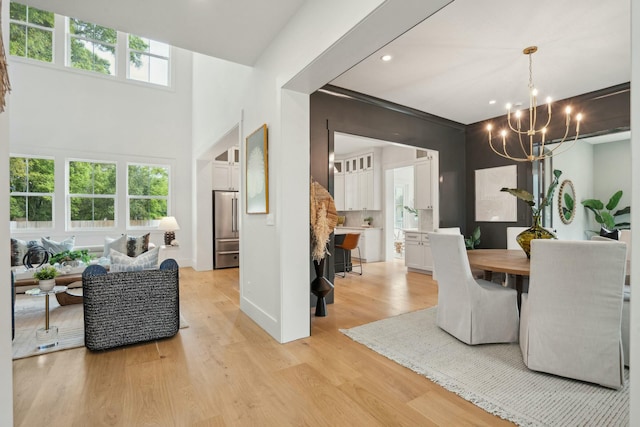 dining area with a chandelier, recessed lighting, light wood finished floors, and baseboards