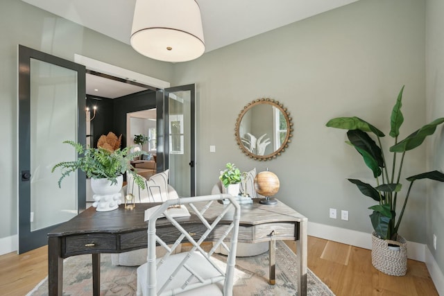 office space featuring baseboards and light wood-style floors