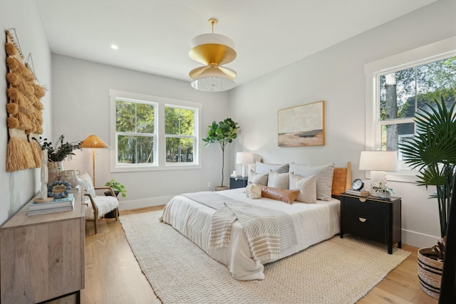 bedroom with recessed lighting, light wood-type flooring, and baseboards