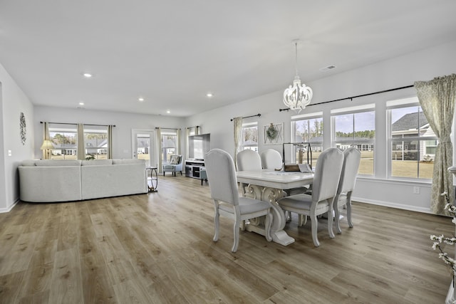 dining area featuring a notable chandelier and light wood-type flooring