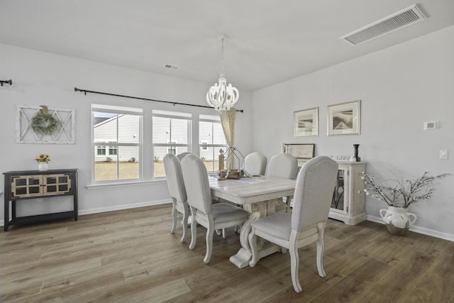 dining room featuring hardwood / wood-style flooring and a notable chandelier