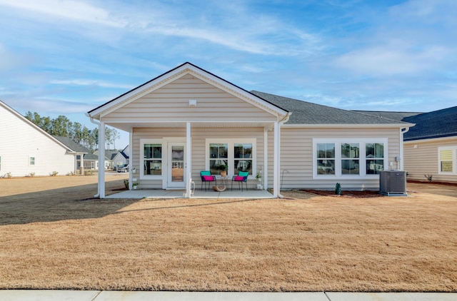 back of property featuring a patio, cooling unit, and a lawn