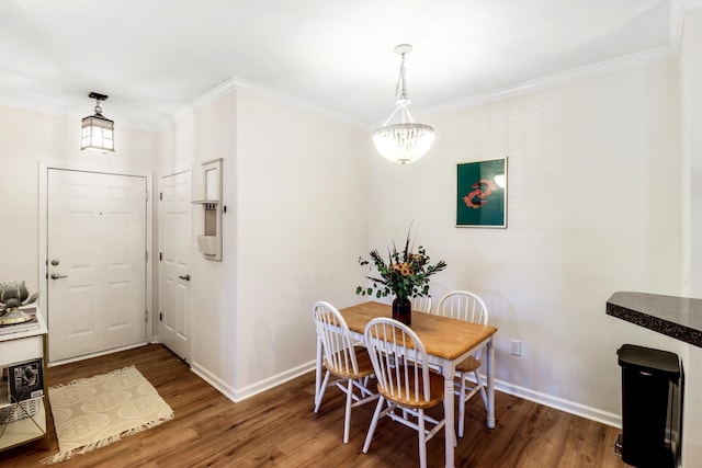 dining area with crown molding, dark hardwood / wood-style floors, and a chandelier