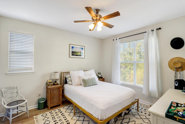 bedroom featuring multiple windows, light hardwood / wood-style floors, and ceiling fan