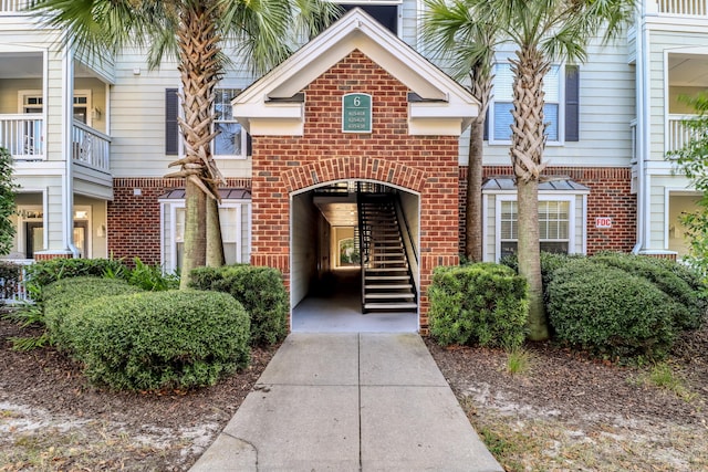 view of exterior entry with a balcony