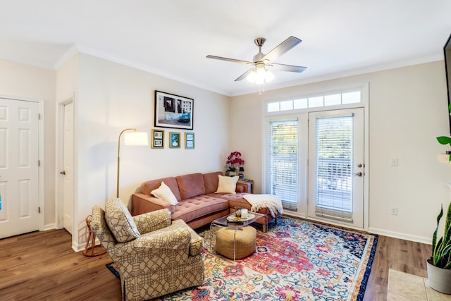 living room with ceiling fan, ornamental molding, and light hardwood / wood-style flooring