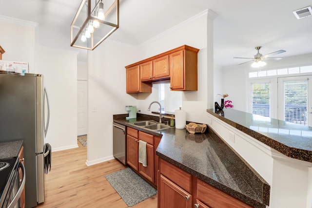 kitchen with appliances with stainless steel finishes, light hardwood / wood-style flooring, ornamental molding, pendant lighting, and sink