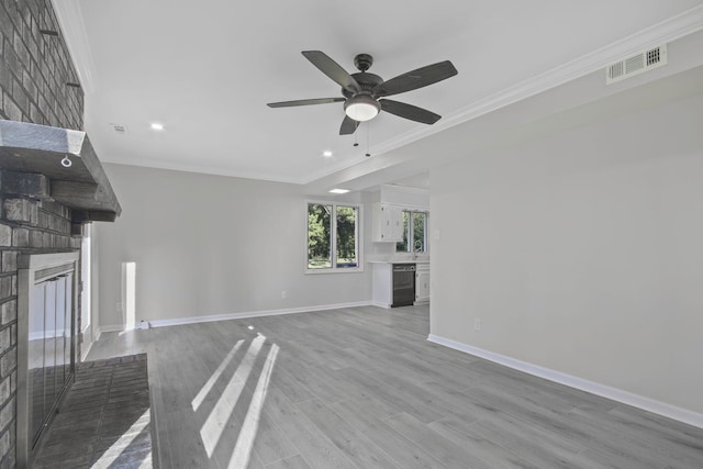 unfurnished living room featuring ceiling fan, ornamental molding, a fireplace, and light wood-type flooring