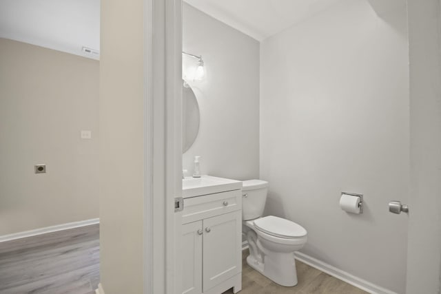 bathroom featuring vanity, wood-type flooring, and toilet