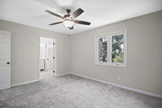 carpeted spare room with ceiling fan