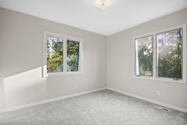 carpeted spare room featuring plenty of natural light