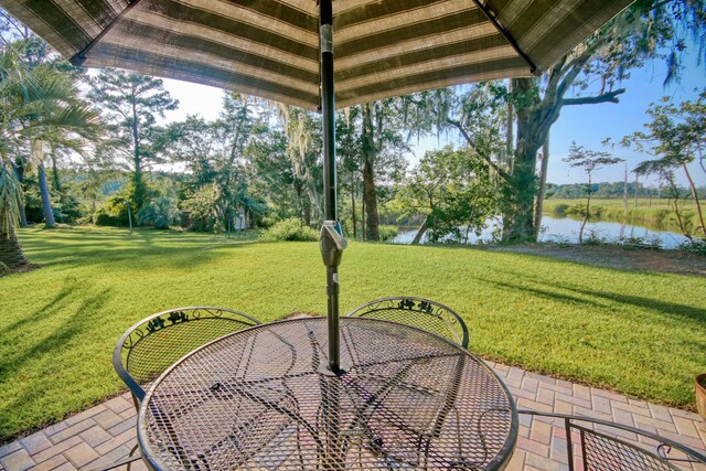 view of yard with a water view and a patio area