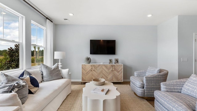 living room with baseboards, visible vents, and recessed lighting