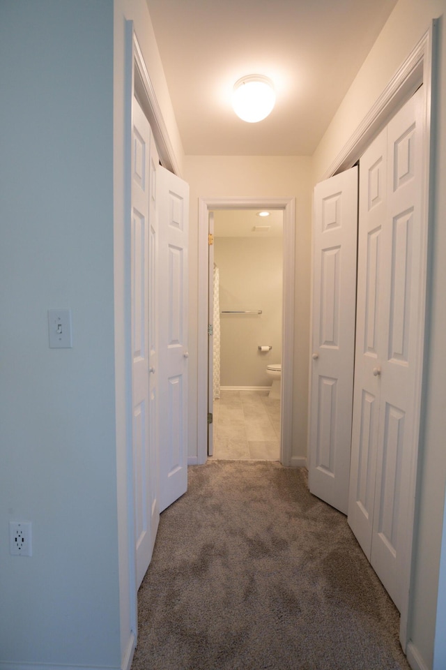 corridor featuring light colored carpet