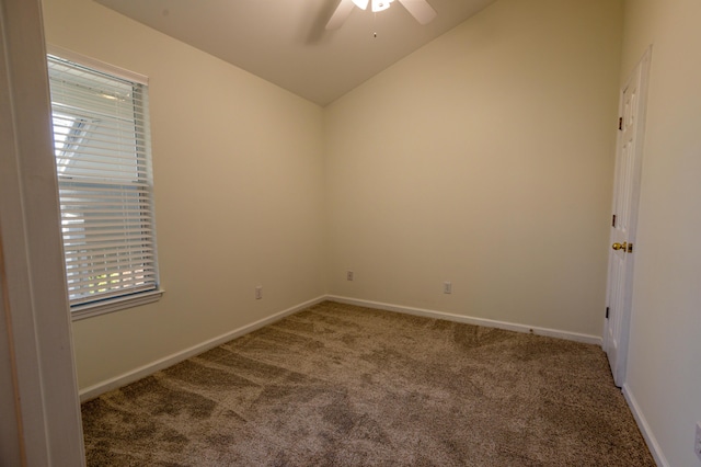 carpeted empty room with ceiling fan, vaulted ceiling, and a wealth of natural light