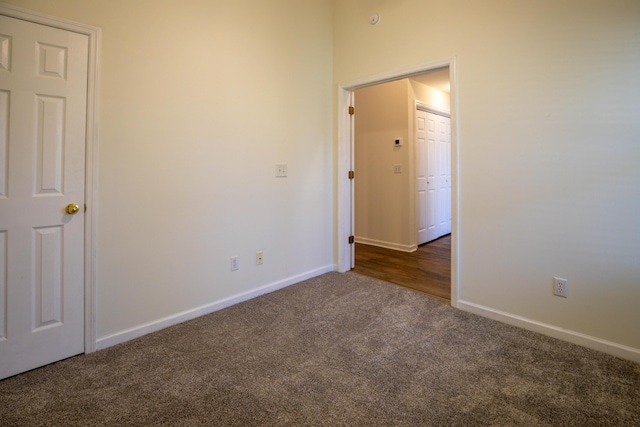 unfurnished room featuring dark colored carpet