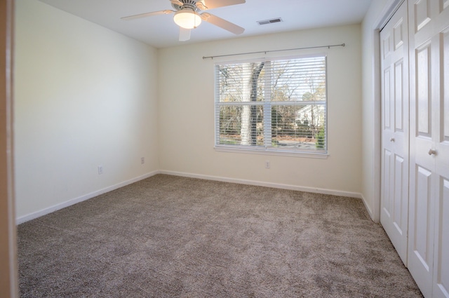 unfurnished bedroom with carpet flooring, ceiling fan, and a closet