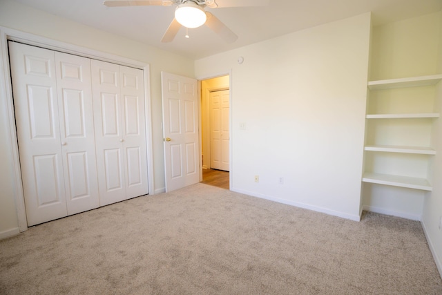 unfurnished bedroom featuring light colored carpet, a closet, and ceiling fan