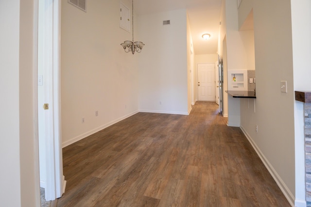 interior space with dark wood-type flooring and a chandelier