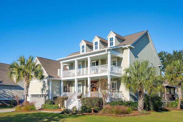 view of front of property featuring a front lawn, stairway, a porch, a garage, and a balcony