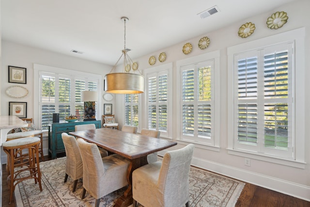 dining space featuring wood finished floors, visible vents, and baseboards