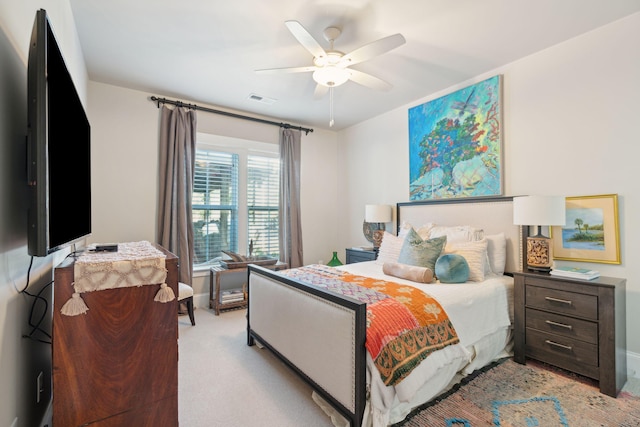 bedroom featuring light carpet, visible vents, and a ceiling fan