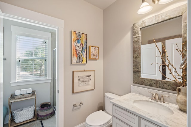 bathroom with a shower with door, toilet, and vanity