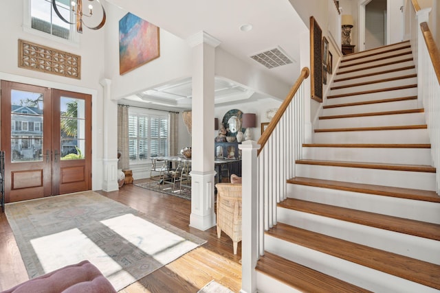 foyer with visible vents, a wainscoted wall, stairway, french doors, and wood finished floors