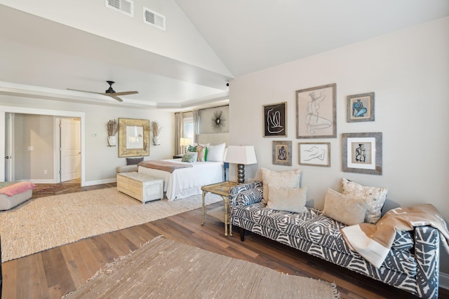 bedroom featuring lofted ceiling, wood finished floors, visible vents, and baseboards